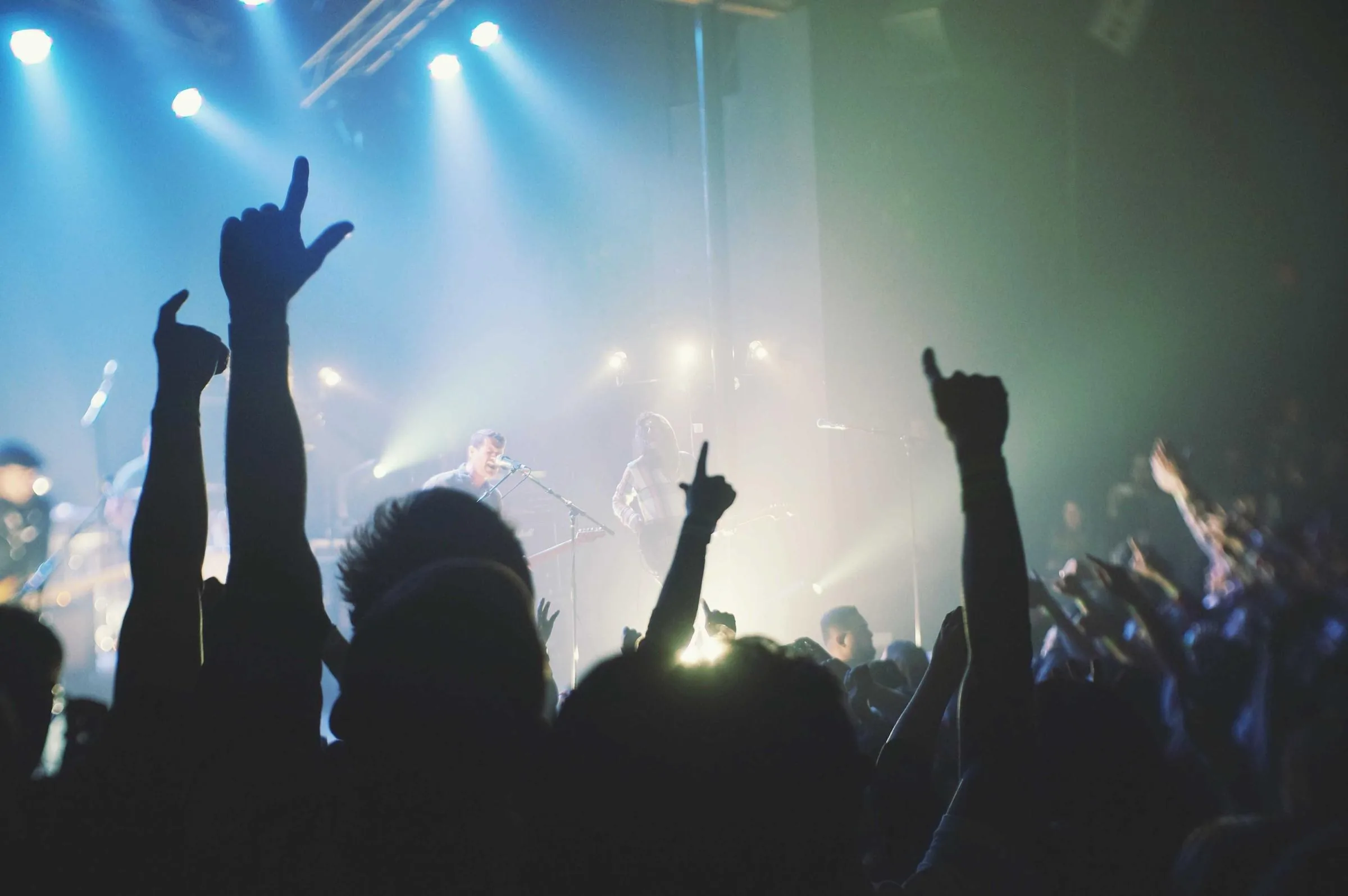 Crowd moving together beneath bright event lights